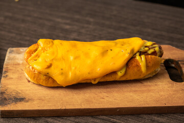A hot dog topped with melted cheese covering