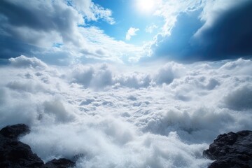 Vast, white clouds billow over a rocky outcrop, a brilliant sun peeks through