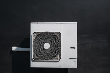 Air conditioner compressor installed on the wall of a building.