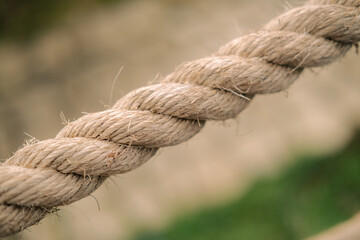 Fototapeta premium Closeup of a thick brown rope suitable for marine, nautical, outdoor, adventure, and rusticthemed designs, websites, posters, and advertising materials.