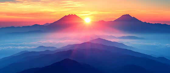 Fototapeta premium Vibrant sunrise over majestic mountain range, showcasing layers of blue and pink hues in the sky and mountains, with fog adding depth.