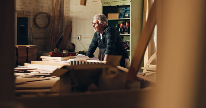 Carpenter, thinking and man in shop, manufacturing and ideas for woodworking in business and table. Construction, entrepreneur and mature person with material for furniture, contemplating and serious - Powered by Adobe