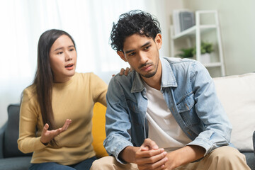 Obraz premium Family problem concept. Tension in relationship between married couple, husband and wife staying sitting separate after quarrel in the living room.