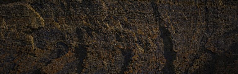 A textured stone background with chiaroscuro lighting, showcasing a brutal, monolithic rock formation. Cracks and fragments highlight its geological power, perfect for design templates or science