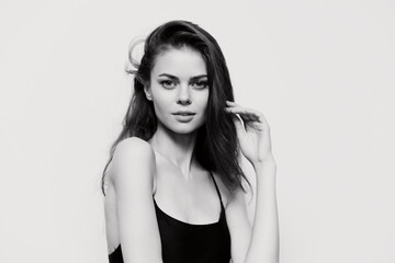 Elegant woman with long hair posing gracefully, showcasing natural beauty in a minimalistic black...