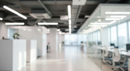 Fototapeta premium Blurry view of a modern office space with desks chairs and bright lighting from large windows overhead