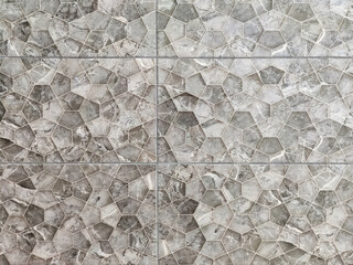Facing tiles of gray geometric pentagonal figures of different shapes. Polygons. Construction materials. Options for finishing walls and floors. Full frame. Black and white photo. Selective focus.