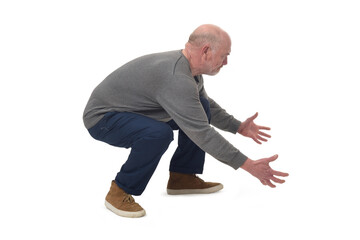 side view of a man lifting something heavy from the ground on white background