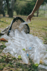 Volunteers collect plastic bottles, put trash in black trash bags to clean the park, avoid pollution, be environmentally friendly and ecologically friendly.