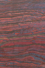 Close up cut red stone with natural patterns and texture. Banded iron ore. Mineral structure, geological layers, natural background for design.