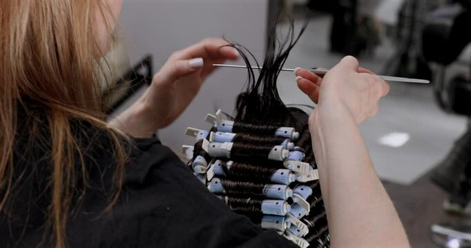 Professional hairdresser working with client, closeup. Hairdresser winding perm rods. Hair curlers.