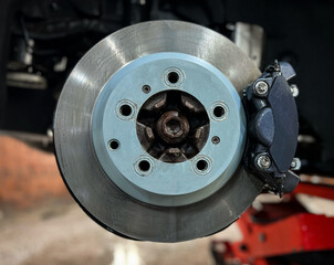 Car brake disc with red caliper. Modern brake disc with holes and cooling. Brake disc and wheel hub...