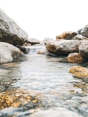 Clear Water Flowing Between Gray and Brown Rocks