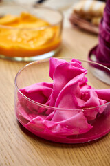 side view of glass flasks with dyed bright fuchsia-colored fabrics, closeup