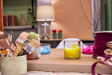 on a table in the workshop are glass flasks with dyed multicolored fabrics, side view