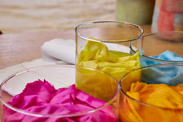 top view of glass flasks with dyed bright fabrics, background for needlework