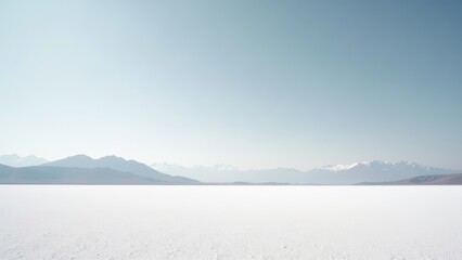 Obraz premium Vast salt flat with distant mountains and soft sky evoking silence and remote isolation 
