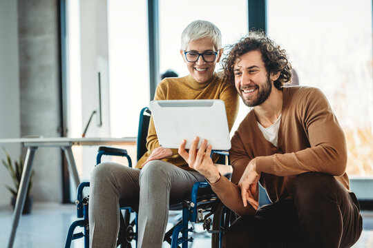 The image includes a person using a wheelchair, depicting inclusivity and teamwork in modern office