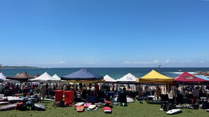 umbrella shade tents in a row outdoors at the beach with group of people at a surf carnival in Australia