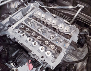 The petrol engine is being overhauled, the camshaft and spark plug assembly can be seen