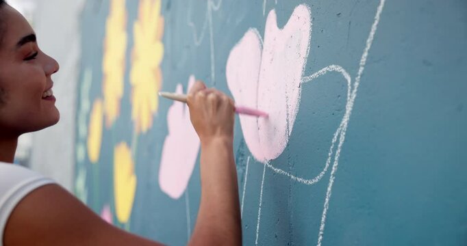 Artist, hand and painting on mural wall for creative flower, decoration design or student in city. Street art, happy woman and painter outdoor with brush for floral color, diy and hobby for culture