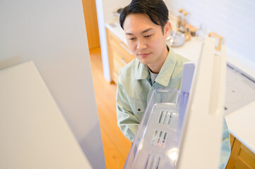 冷蔵庫を点検する日本人男性