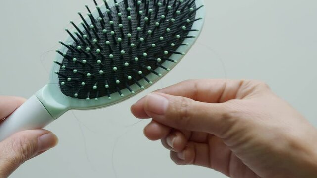 Woman holding comb and litte loss hair