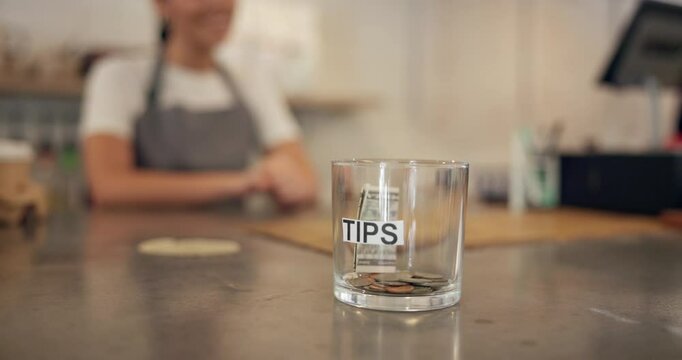 Hand, person and money for tips at cafe of customer gratitude, community contribution and payment method. Closeup, client and jar for cash transaction, good service and staff reward of finance income