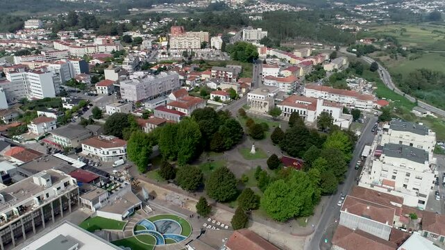 Drone footage shows the centre of Paredes, from an upview. There are trees and buildings, it's located in Portugal.