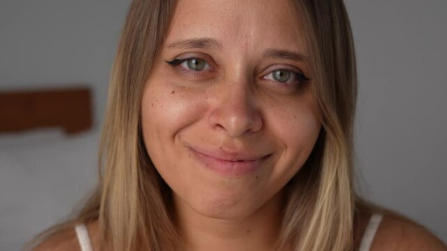 Close-up of a young blonde woman's face with tears of joy in her eyes. A heartfelt moment of deep emotional release, self-acceptance and unconditional love, expressed with tenderness and light