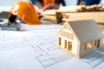 Construction planning with wooden model house on layout design table at workshop