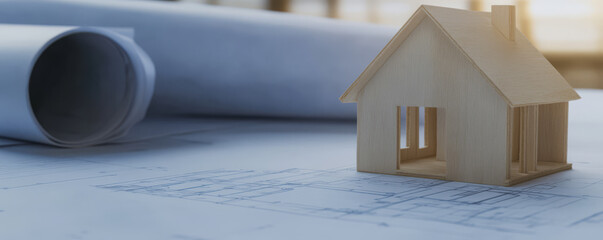 Model house on architectural blueprints in a design studio during daylight hours