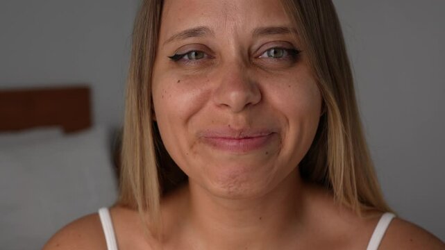 Close-up of a young blonde woman with green eyes crying and smiling at the same time feeling tears of joy. A deeply emotional and genuine moment of happiness, release, and raw, heartfelt joy