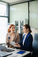 Asian business colleague business presents and explains and using laptop and tablet. Teamwork