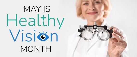 Female ophthalmologist with trial frame on light background, closeup. Healthy Vision Month