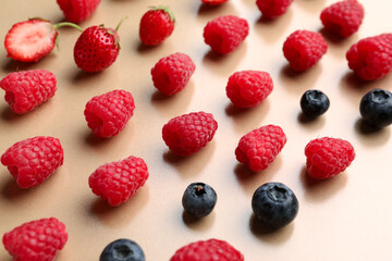 Fresh raspberries, blueberries and strawberries on beige background