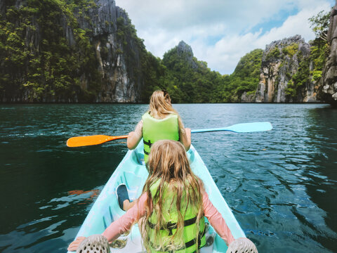 Kayaking tour in Philippines - family mother and child traveling together summer vacations in Asia, active lifestyle adventure trip parent mom and daughter tourists exploring Palawan island lagoon