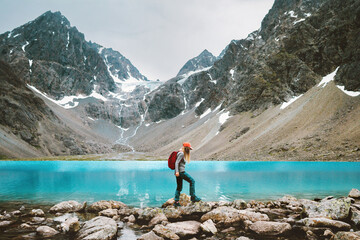 Woman traveler climbing in mountains with Blavatnet lake view in Norway active adventure travel, active tourist hiking solo Lyngen Alps healthy lifestyle summer vacations in the wild
