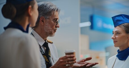 Airline Captain in Glasses Talks to Two Beautiful Stewardesses in Uniforms, Drinks Coffee, Waits...