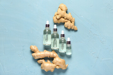 Bottles of ginger cosmetic oil on blue background