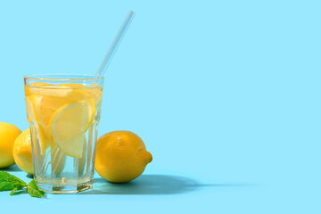 Glass of tasty lemonade with mint on blue background