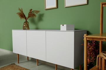 Interior of stylish living room with modern white chest of drawers