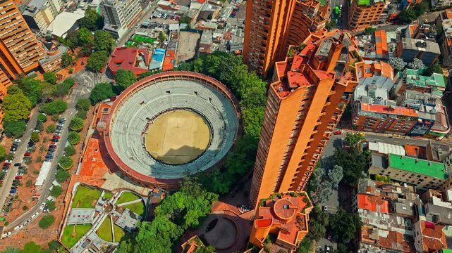 Aerial fly above Bullring in Bicentenario Urban park of Bogota city, Colombia, traffic, colorful cityscape of South American capital town