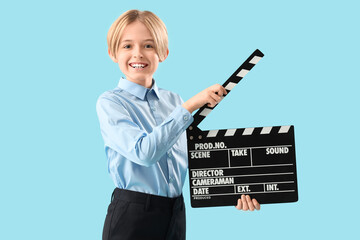 Little actor with movie clapper on blue background