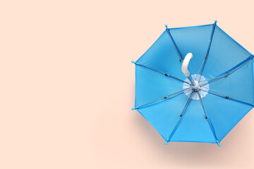 Mini stylish umbrella on beige background