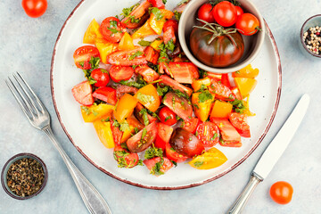 Fresh salad preparation with tomatoes and greens.