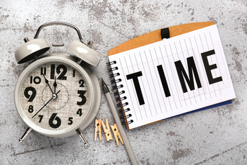 Notebook with text TIME and alarm clock on grey background. Time management concept. Top view