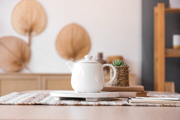 Teapot on dining table in room, closeup