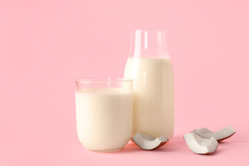 Glass and bottle of coconut milk on pink background