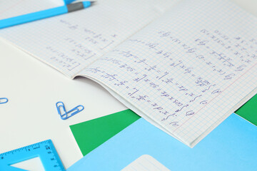 Copybook with math formulas on light table, closeup